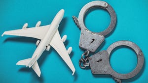 An airplane figurine next to handcuffs on a blue background