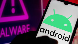 A shadowed hand holding a mobile device with the Android logo on the screen next to a computer screen that says "malware" with an exclamation point A shadowed hand holding a mobile device with the Android logo on the screen next to a computer screen that says "malware" with an exclamation point