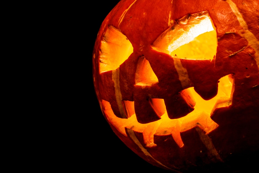 creepy lit jack-o-lantern pumpkin on black background