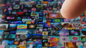 Images of nonfungible tokens clustered together on a screen with an index finger hovering above as if to press on one Images of nonfungible tokens clustered together on a screen with an index finger hovering above as if to press on one
