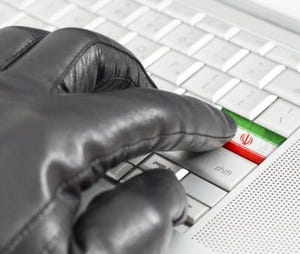 Gloved hand on keyboard with finger touching a key with an Iranian flag
