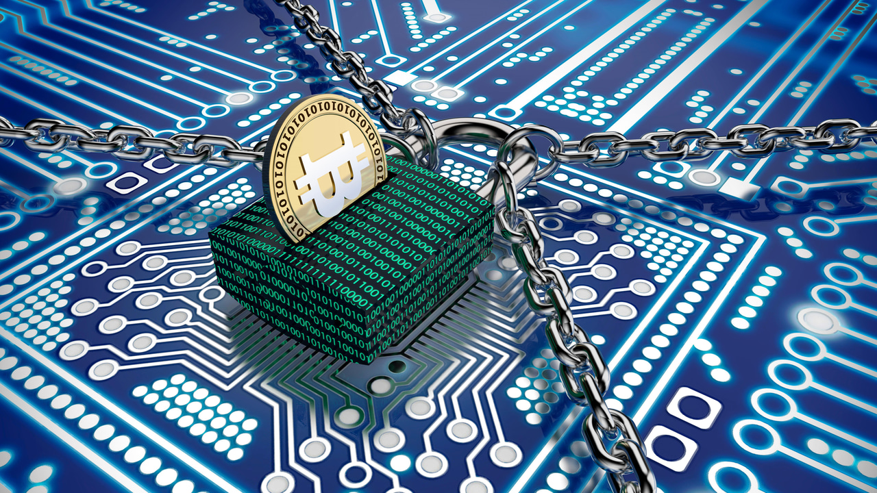 ランサムウェアを概念化した、"物理的な"ビットコインが挿入されているロックの写真 ランサムウェアを概念化した、"物理的な"ビットコインが挿入されているロックの写真