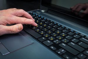 Man typing on a keyboard with letters in Hebrew and English