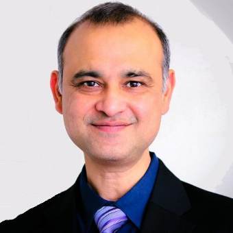 Archie Agarwal, Founder and CEO at ThreatModeler, wears a black jacket, a dark blue shirt, and a very nice purple striped tie.