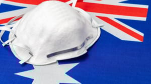 An N95 mask on top of a flag of Australia. An N95 mask on top of a flag of Australia.