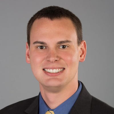 David Stone is part of Google Cloud and is wearing a black suit, blue shirt, and a yellow tie with blue stripes. David Stone is part of Google Cloud and is wearing a black suit, blue shirt, and a yellow tie with blue stripes.