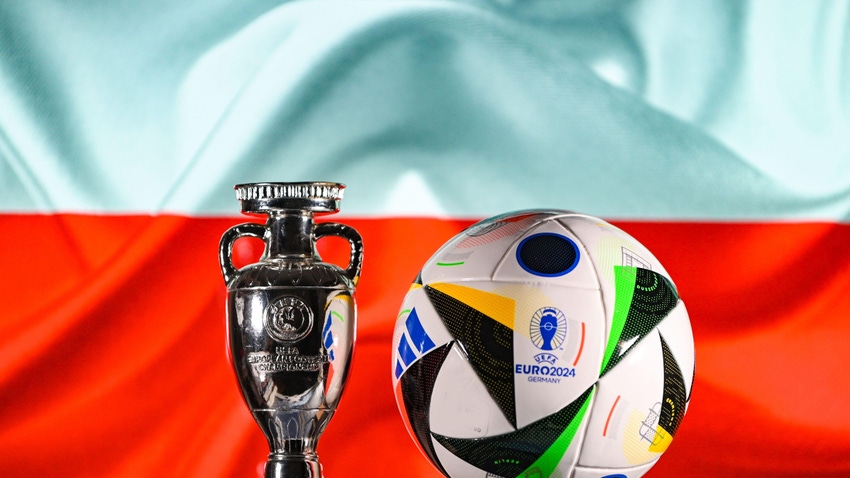 Official ball of the UEFA Euro 2024 and the European Cup on the background of the flag of Poland.