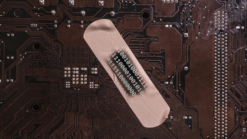 A bandaid on top of a piece of computer hardware with lines of code superimposed on top of it