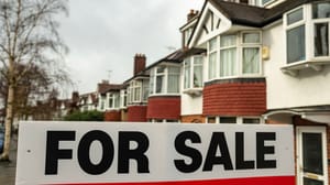 For Sale sign in front of a row of houses For Sale sign in front of a row of houses