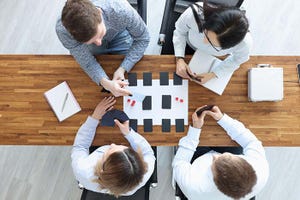 Group of people sitting at table and playing board games top view.