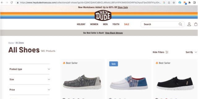 Screenshot of the real website for Hey Dude shoe brand, with rainbow stripe and '70s-style logo