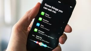 A person's hand holding a phone with Siri pulled up providing recommendations of different commands A person's hand holding a phone with Siri pulled up providing recommendations of different commands
