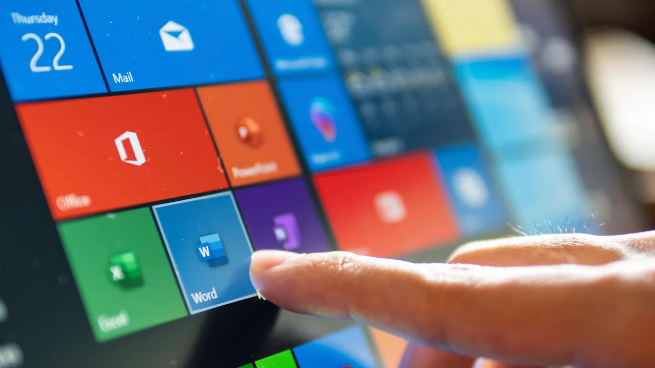 Microsoft 365アプリが表示されたタッチスクリーンデバイスを指でタップしている人 Microsoft 365アプリが表示されたタッチスクリーンデバイスを指でタップしている人