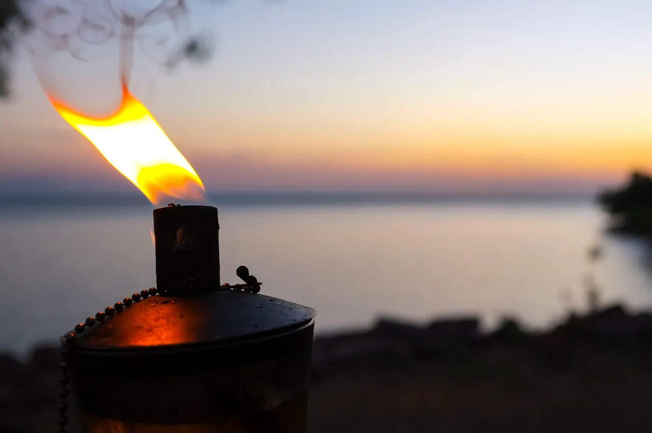 Tiki torch near the beach at sunset Tiki torch near the beach at sunset