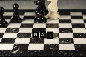 Chess board with the word "rat" spelled out in Scrabble letters and chess pieces in the background
