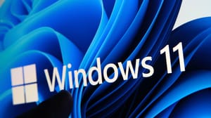 A person's finger about to click on a screen that says Windows 11 with a blue abstract background behind it A person's finger about to click on a screen that says Windows 11 with a blue abstract background behind it