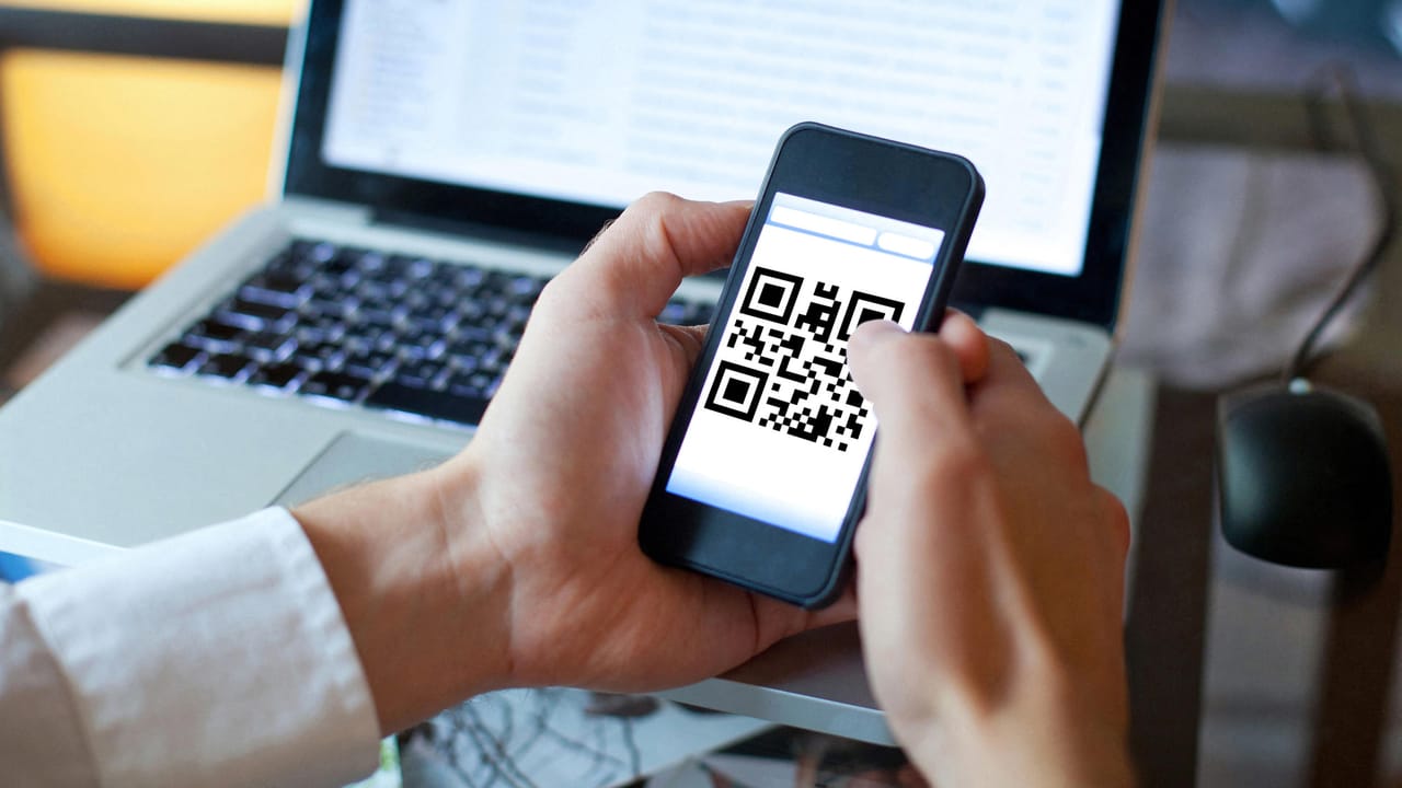 画面にQRコードが表示されたスマートフォン。 画面にQRコードが表示されたスマートフォン。