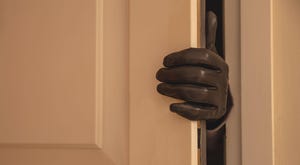 gloved hand opening a front door