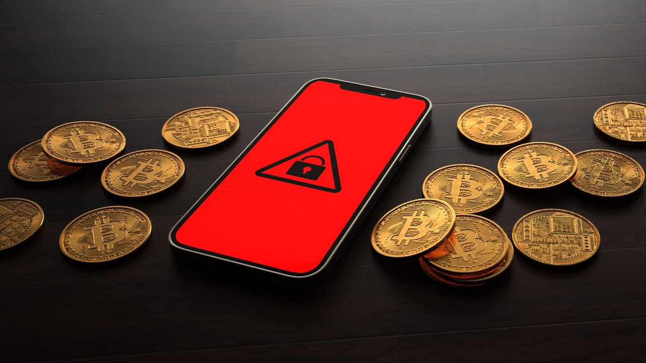ランサムウェア支払いを表す、ロックされたスマートフォンと物理的なビットコインのビジュアルコンセプト ランサムウェア支払いを表す、ロックされたスマートフォンと物理的なビットコインのビジュアルコンセプト
