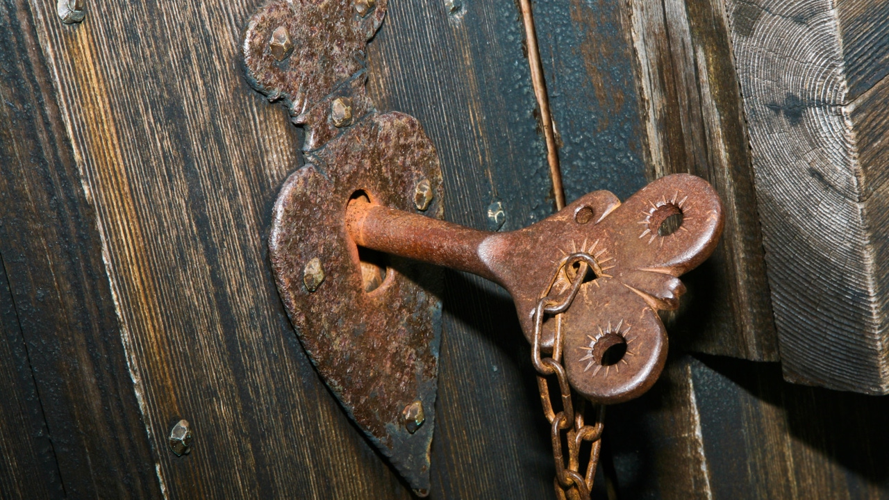 Close up of historic church front door with shaped key in keyhole Close up of historic church front door with shaped key in keyhole