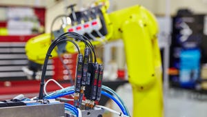 Yellow industrial robotic arm and electrical components in automated facility