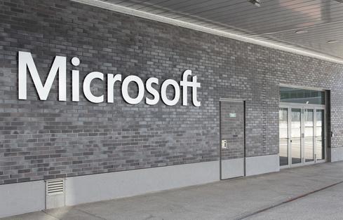 Entrance of the Microsoft Switzerland Ltd office, with silver letters spelling 'Microsoft' on a gray brick wall