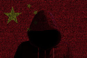 Hacker wearing a hoodie on red digital Chinese flag
