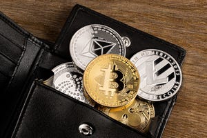 Various cryptocurrency coins like Bitcoin spread on top of a wallet
