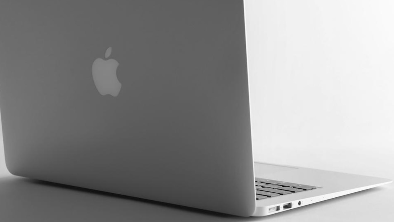 An Apple macOS laptop open on a desk An Apple macOS laptop open on a desk