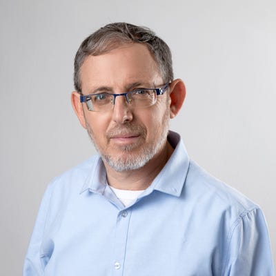 David Movshovitz, CTO and co-founder of RevealSecurity, has short graying hair, glasses, and a short beard.