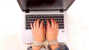 Woman's bound hands typing on a keyboard