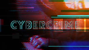 The word CYBERCRIME over a dark but colorful digital background; hands can be seen on a laptop keyboard