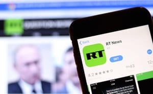 RT news logo in app store and screen grab in background RT news logo in app store and screen grab in background