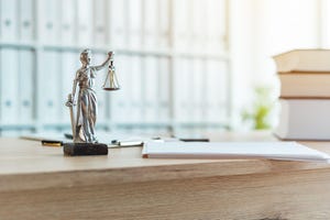 desk with figure holding the scales of justice