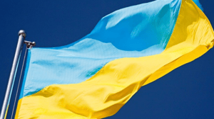 Blue-and-yellow Ukraine flag blowing in the wind against a blue sky Blue-and-yellow Ukraine flag blowing in the wind against a blue sky