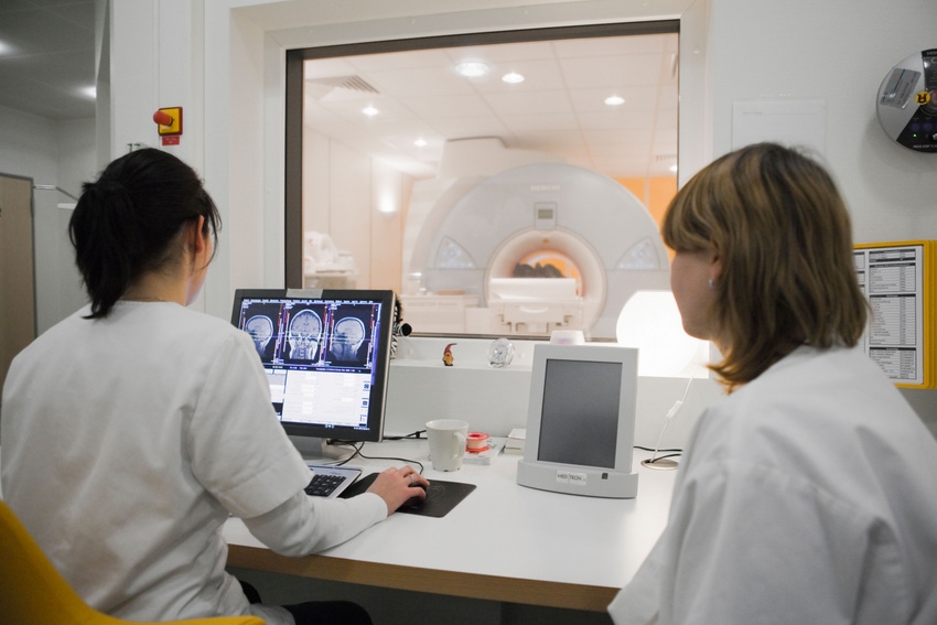 two medical professionals viewing medical imaging scans.