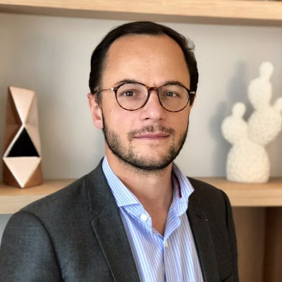 Laurent Célérier has short dark hair and beard, wearing round horn-rimmed glasses, an open collared shirt, and a dark blazer Laurent Célérier has short dark hair and beard, wearing round horn-rimmed glasses, an open collared shirt, and a dark blazer