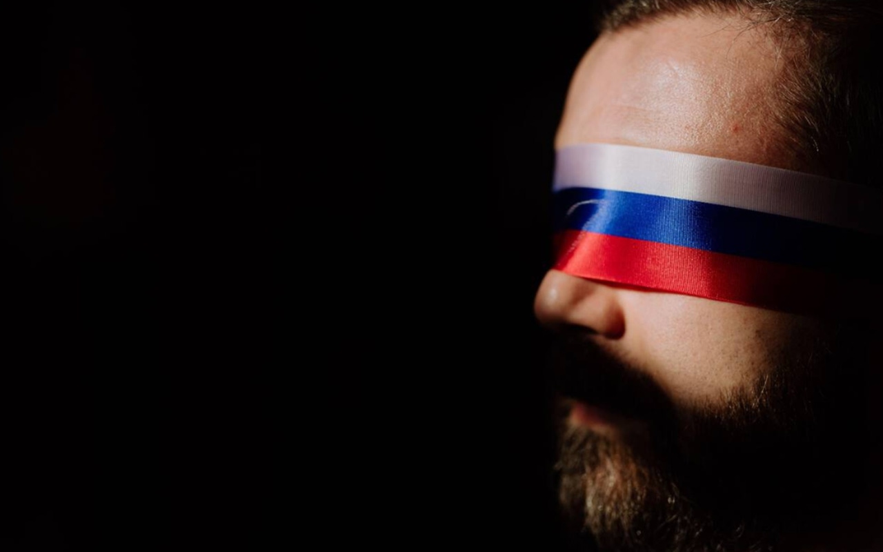 Man blindfolded with russian colors to represent propaganda Man blindfolded with russian colors to represent propaganda