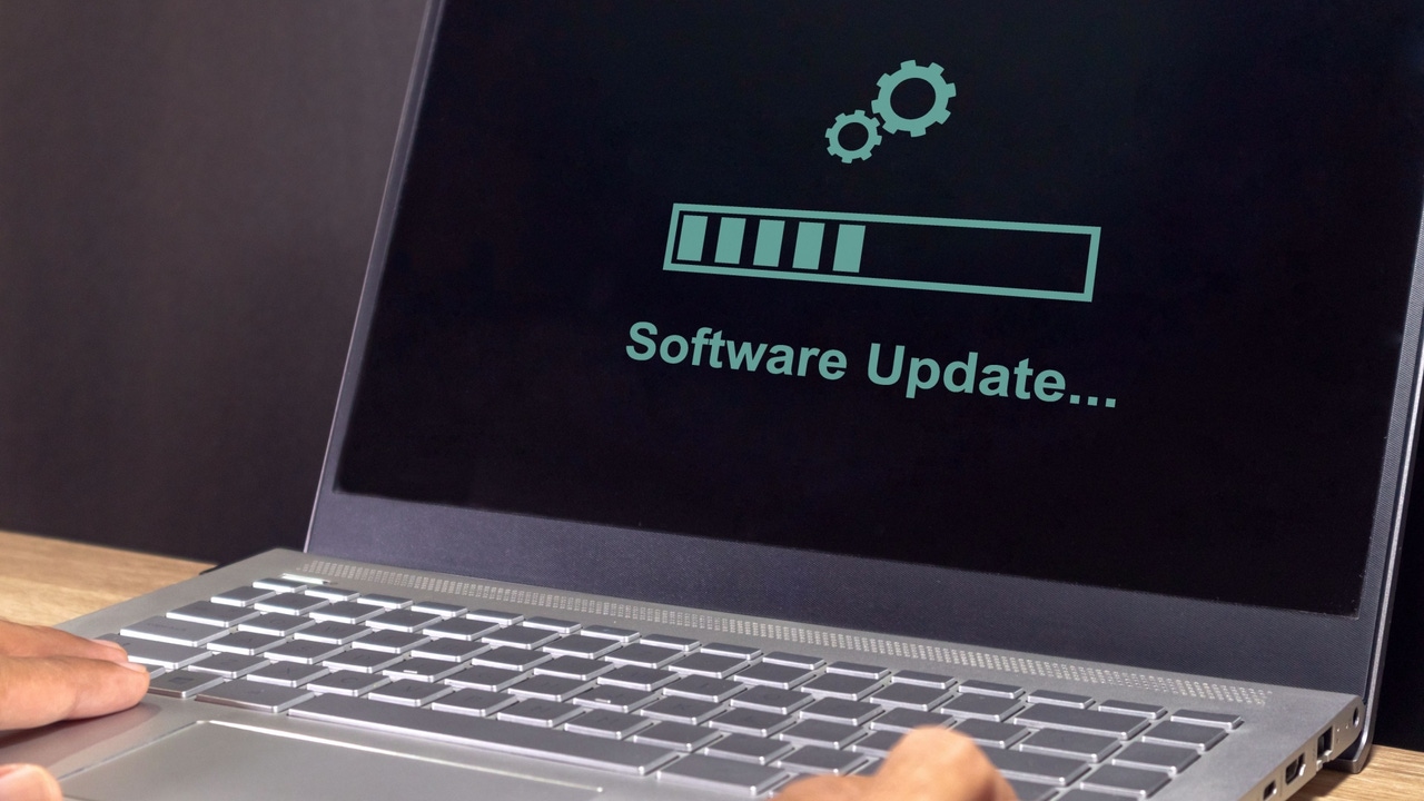 A laptop on the table with software update progress bar on screen