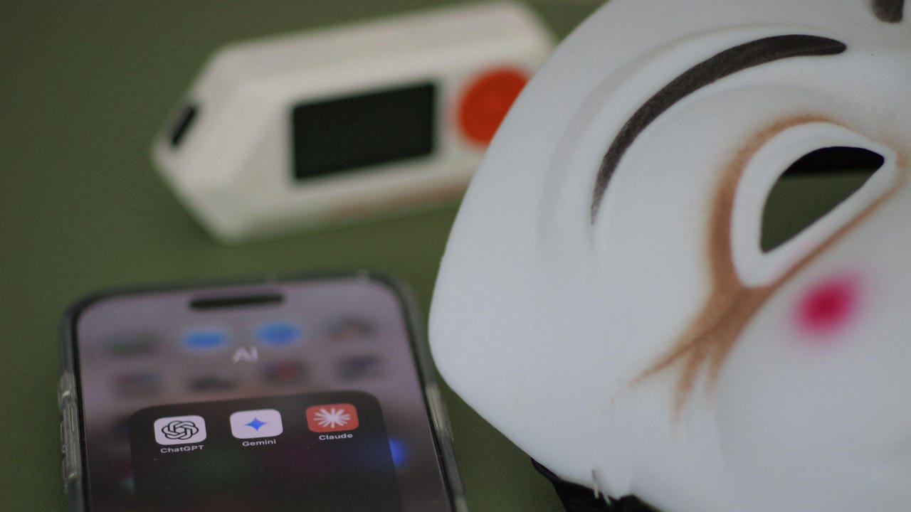 A Guy Fawkes mask next to a phone with various LLM apps on it A Guy Fawkes mask next to a phone with various LLM apps on it