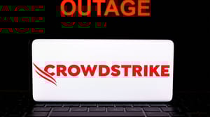 CrowdStrike logo seen on screen of smartphone and the word OUTAGE seen behind it CrowdStrike logo seen on screen of smartphone and the word OUTAGE seen behind it