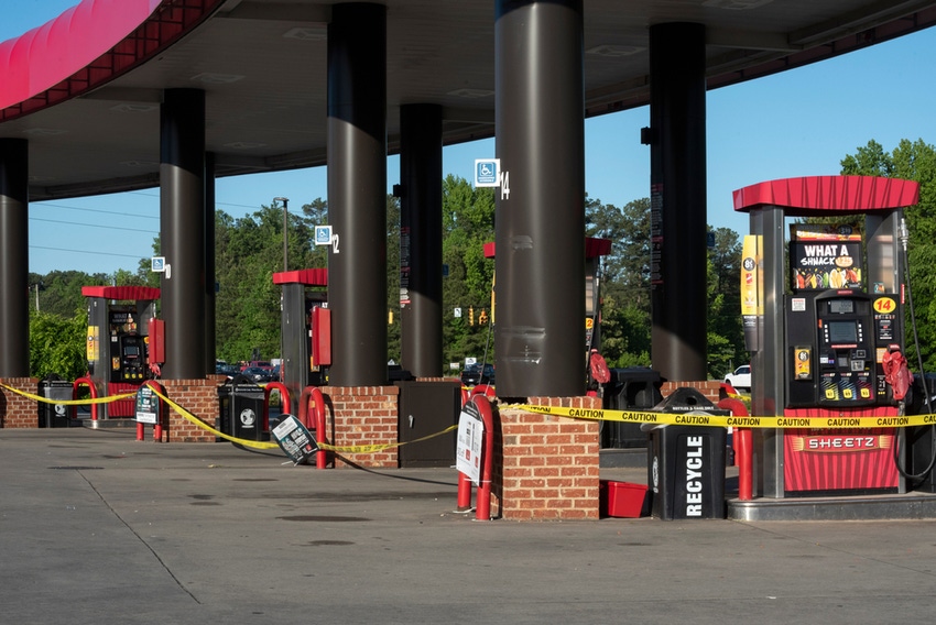 Yellow tape marks empty pumps at a deserted gas station following colonial pipeline attack