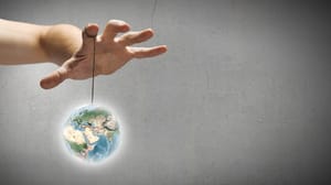 A hand with a tiny Earth hanging from a string A hand with a tiny Earth hanging from a string