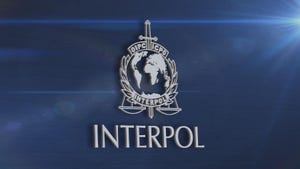 Interpol logo in grey on a navy blue wall