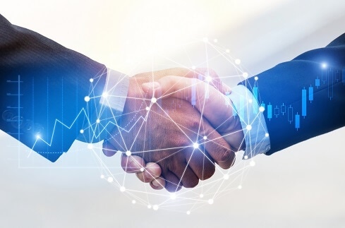 Two people shaking hands surrounded by networks and other technology images.
