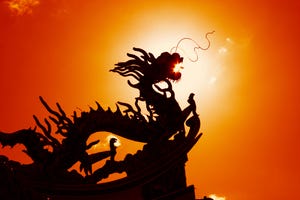 silhoutte of dragon carving on Chinese temple roof with dramatic red bloodlight