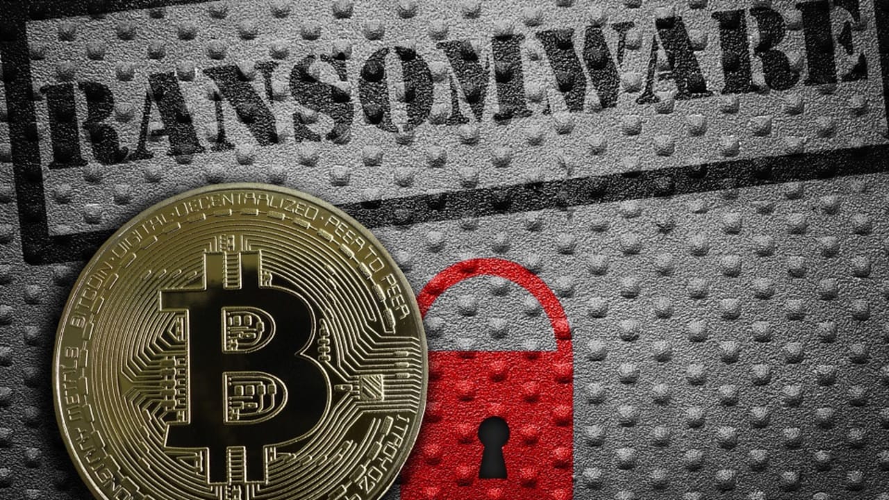 A red padlock next to a gold coin with a B in the middle under the word "ransomware" A red padlock next to a gold coin with a B in the middle under the word "ransomware"