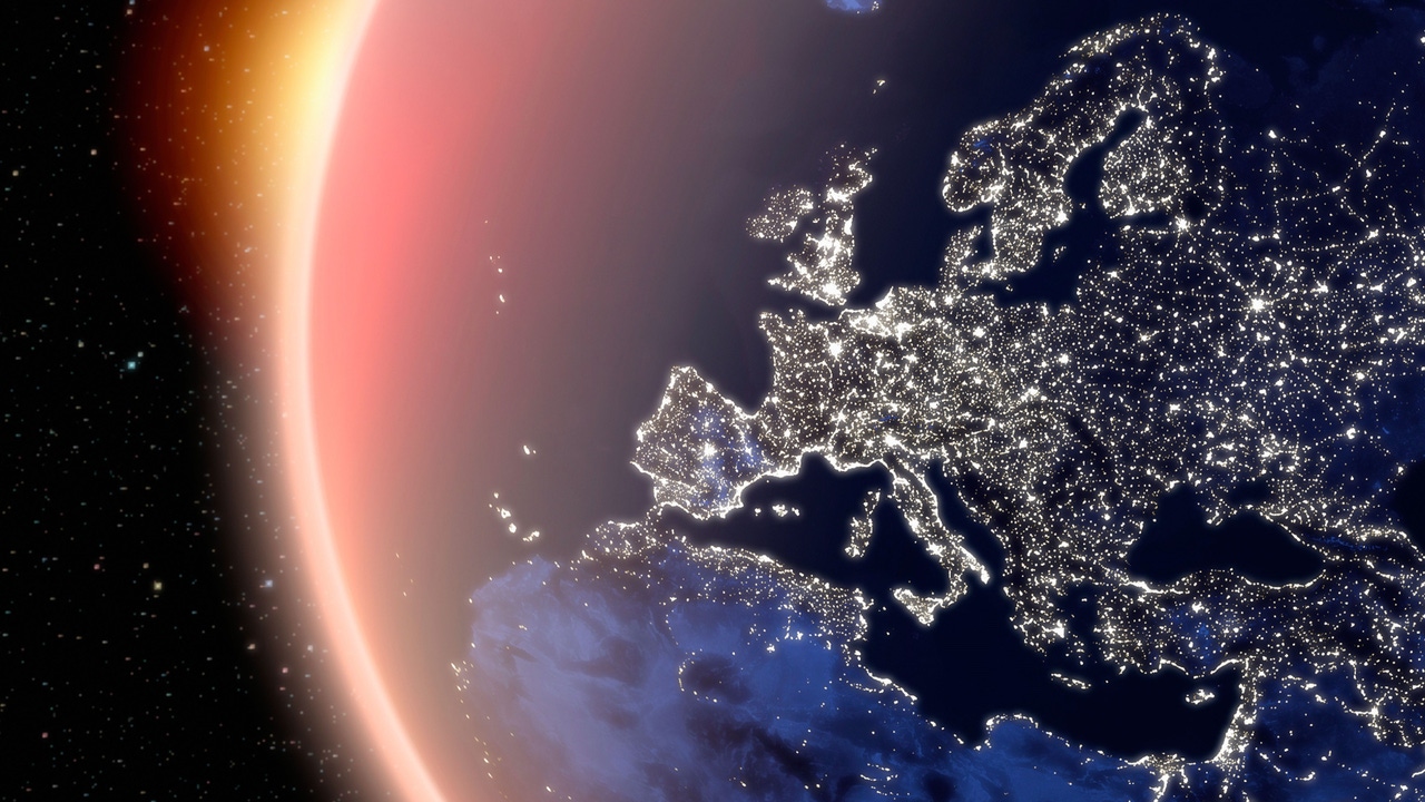 A view of earth showing the lights on in Europe, with the sun ringing the planet A view of earth showing the lights on in Europe, with the sun ringing the planet