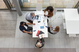 A four-person team working together around a conference table.