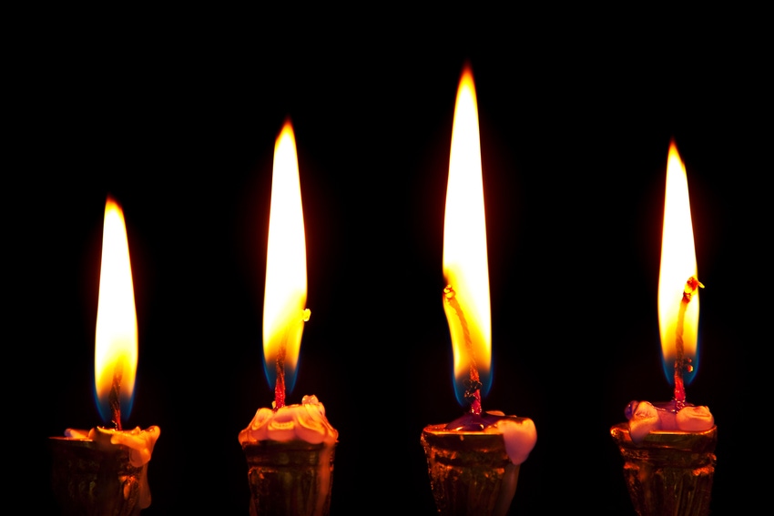 Burning hanukkah candles in a menorah on black background